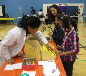 Young girls trying science experiments at a community event