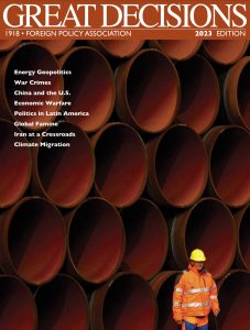 Cover of Great Decisions policy book showing topic titles and photo of stacked large pipe sections and worker wearing a hard hat and safety vest.