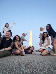 Eight college women leaders pose with the Washington Monument in the background, June 2023