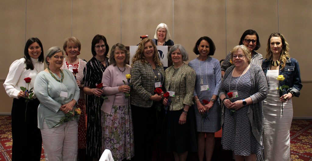 Group of 12 women standing in front of a podium