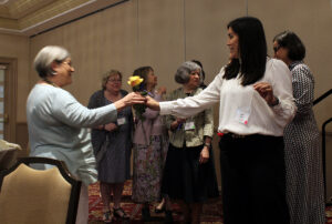 Branch I-ACT lead Susan Marshall (left) receives a rose from President Elect Nikki Batsch